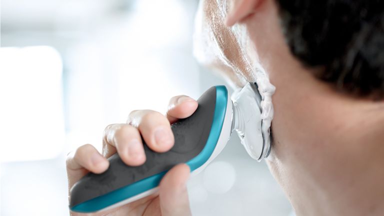 A man shaving his face with one of the best electric shavers
