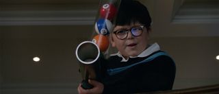 Archie Yates pointing a gun with pool balls in Home Sweet Home Alone
