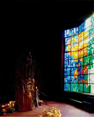 Interior view of the Pilgrimage Church. Stained glass window to the right lets in the light. The colors of the stained glass are green, blue, orange, red, and yellow.