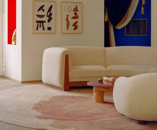 A living room with beige chairs and pink carpet