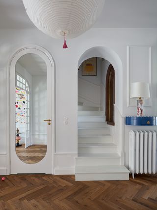 an arched hallway with a pill shape mirror