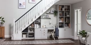 white home office built-in under staircase