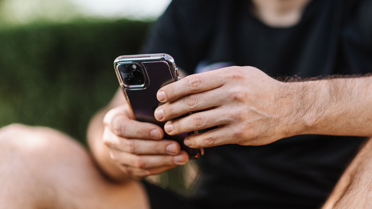 Apple iPhone being held by an adult male