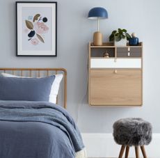 Grey bedroom with wooden bedframe and floating bedside table