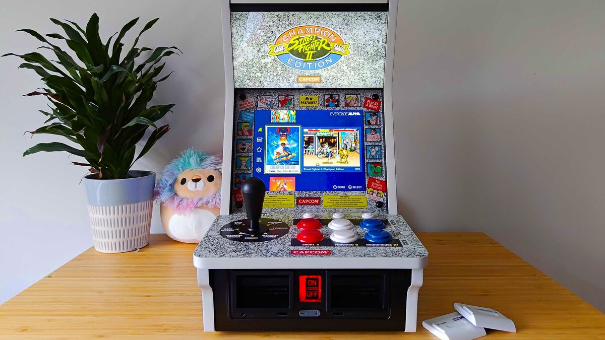 Front view of Evercade Alpha next to cartridges with game menu displayed