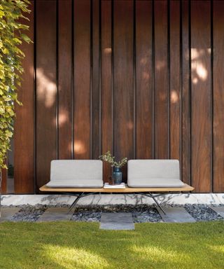Dark wood fence with low sofa in garden