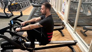 Callum Booth taking part in an Apple Fitness+ class on a rowing machine