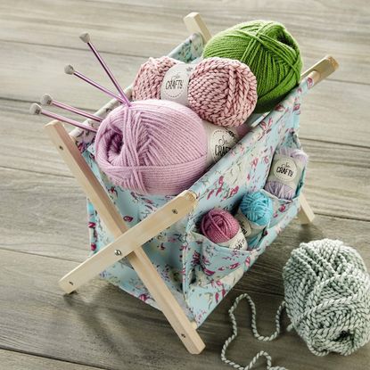 wooden table with wooden fabric box containing knitting needle and yarns