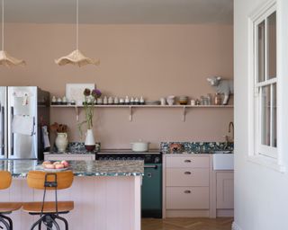 kitchen with plaster pink walls and cabinets and island