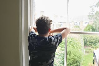 teenage boy looking out of the window