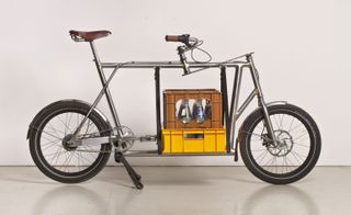 Old fashioned metal framed bike with crate of bottles attached in the middle of frame