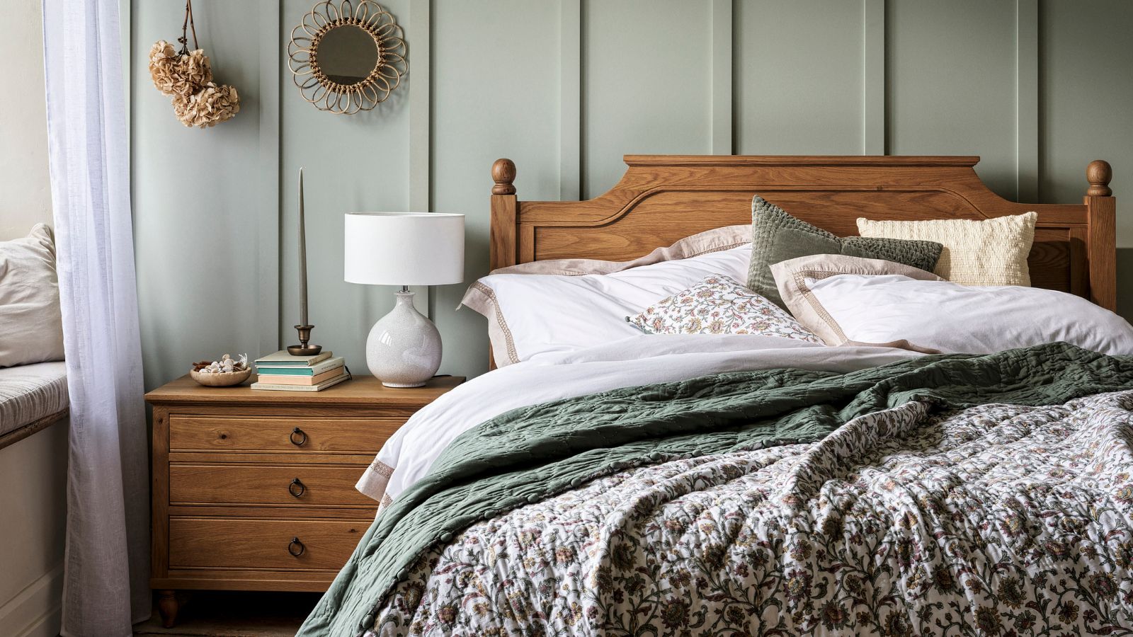 A blue panelled bedroom with a wooden bed and matching night stand. 