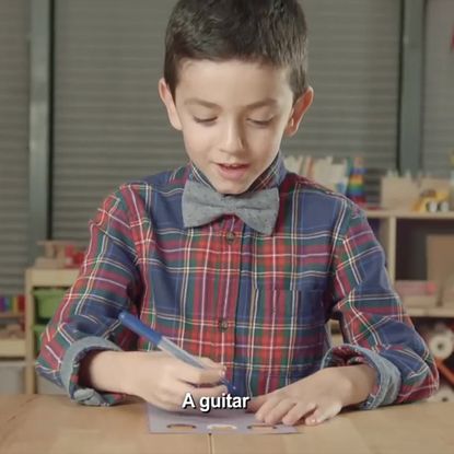 boy is writing a guitar for christmas