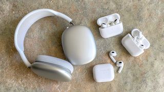 Apple AirPods models on a stone floor showing AirPods Max, AirPods Pro, AirPods Pro 2 and AirPods 3