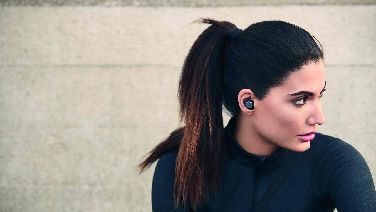 Jabra Elite Active 75t review: Pictured here, fit young woman wearing the buds looking away from the camera