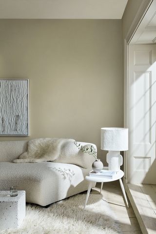 Cozy living room painted in Little Greene with boucle sofa and fur throw