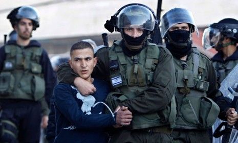 An Israeli security officer detains a Palestinian stone-thrower during clashes in Gaza on Nov. 15.