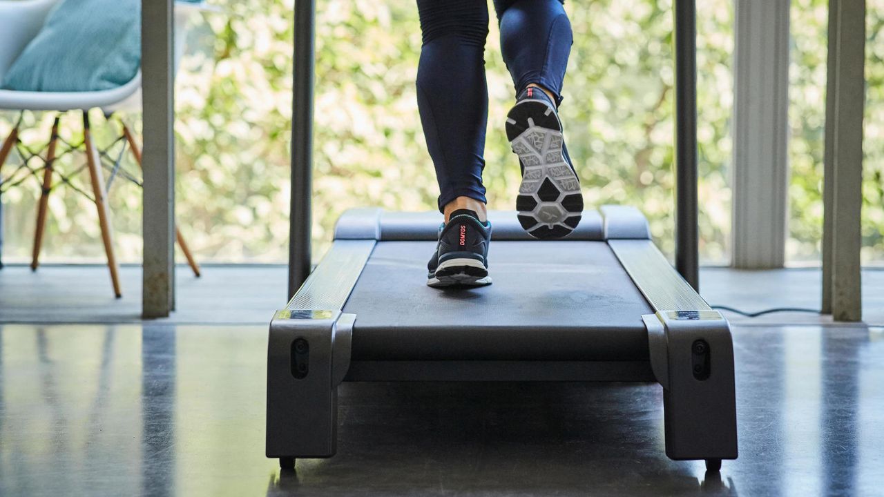 Person running on the Domyos Comfort Treadmill T520B in a spacious living room