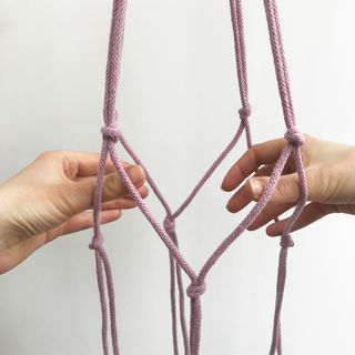 hand holding purple cord with knots tied