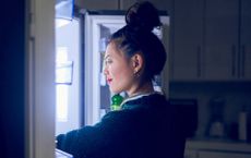 Young woman looking in the fridge for the best food to eat at night