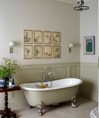 Neutral bathroom with paneling and roll top bath