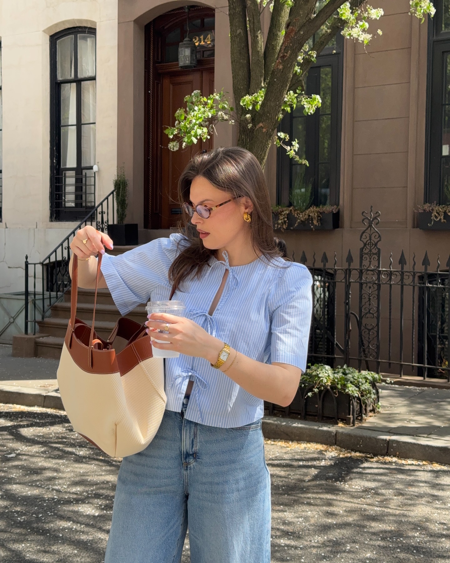 Maggie McCormack wears a tie blouse, blue jeans and a basket bag.