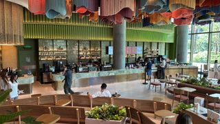 The interior of a Thai Starbucks with a lot of green decor. 