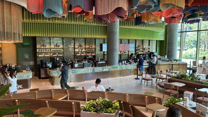 The interior of a Thai Starbucks with a lot of green decor. 