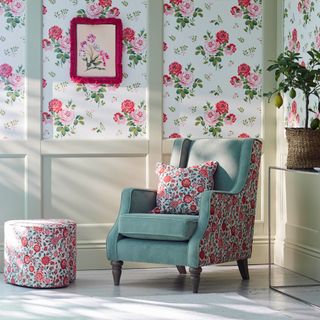Blue-green armchair with floral patterned sides and matching footstool