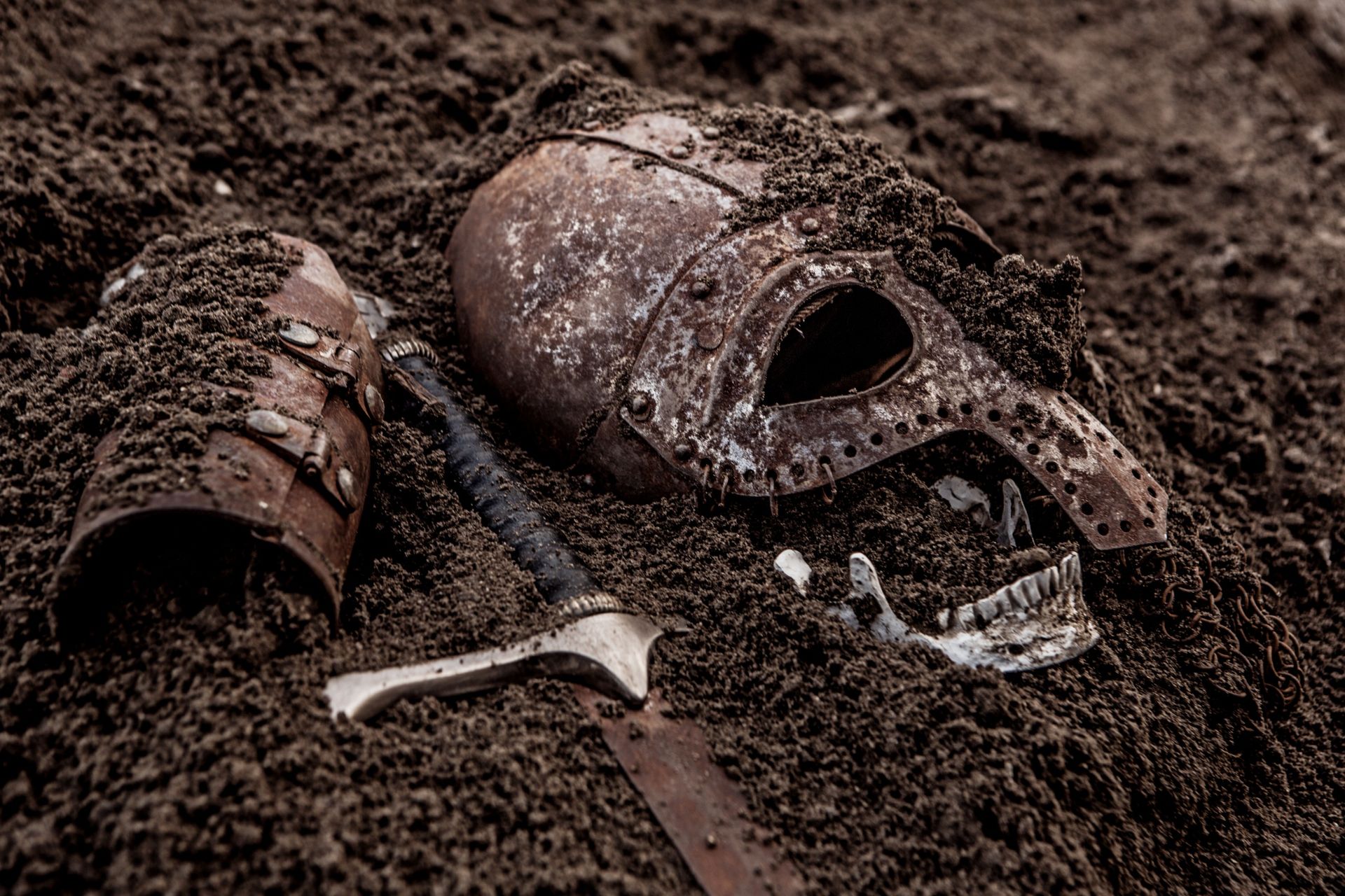 A viking sword, gauntlet and helmet in dirt