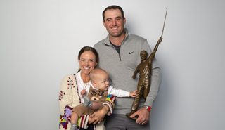 Scottie Scheffler poses with the PGA Tour Player of the Year award with his wife and child