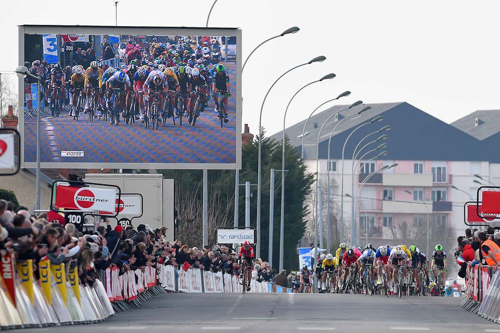 A big screen captures the action at the finish.