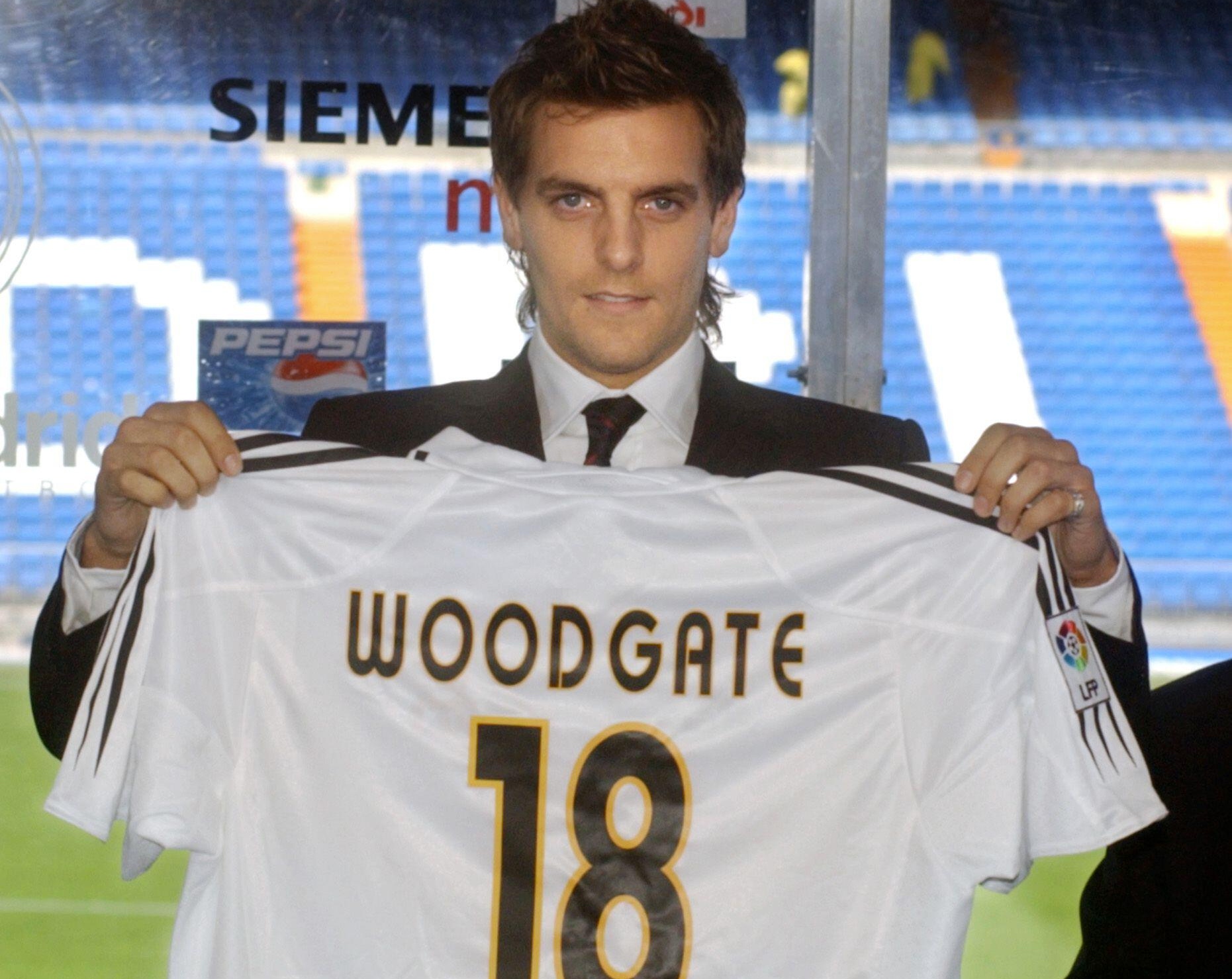 Jonathan Woodgate holds up his shirt after signing for Real Madrid, 2004