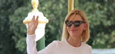 Cate Blanchett wearing Louis Vuitton sunglasses and a white top, waving