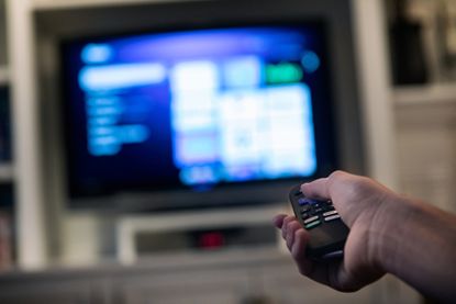 A consumer in a home using a modern smart television to stream various content.