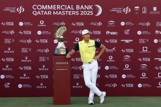 Haotong Li poses next to the Qatar Masters trophy in 2025