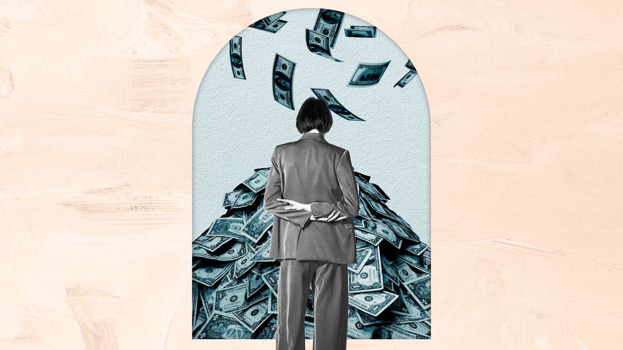 Woman in a suit looking at a pile of money as more falls from the sky