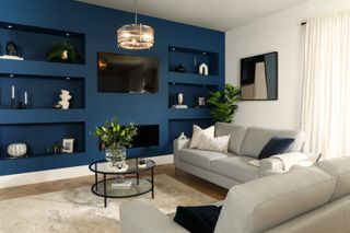 A living room with bookshelf painted deep navy blue