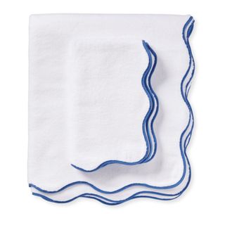 A white bath towel with a blue wavy trim