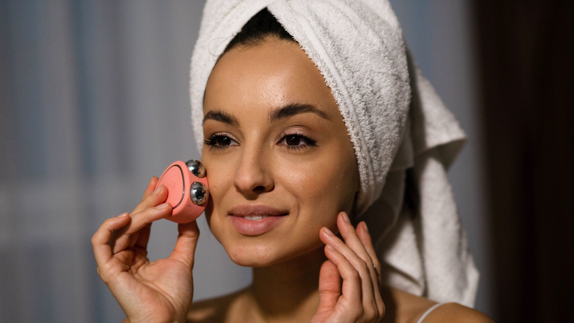 Black friday skincare tools - woman using microcurrent device