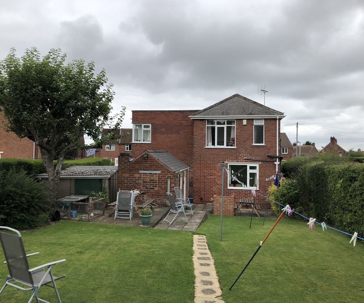The before image of a house which is about to be renovated and extended. A large lawn in the back garden