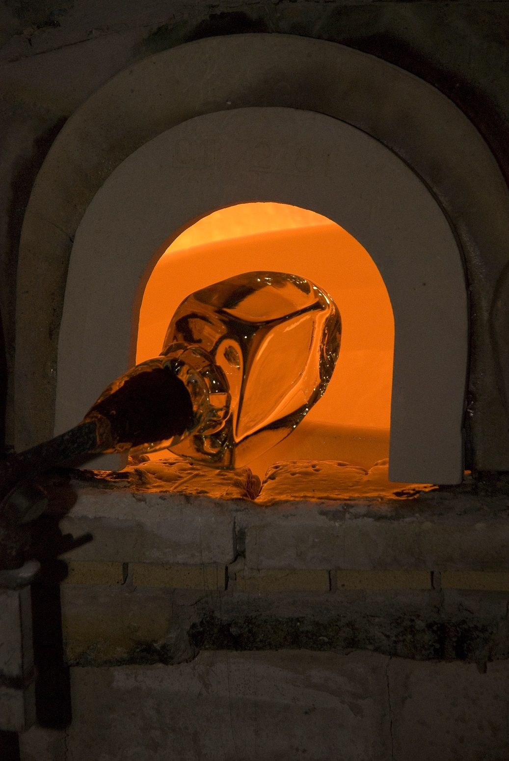 A ball of glass enters the oven of a furnace.