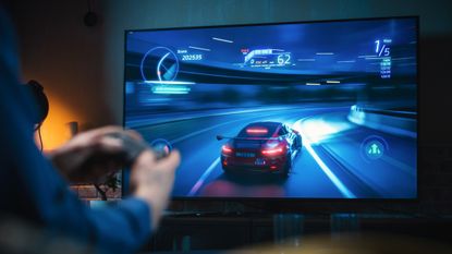 a gaming monitor with someone playing a racing game