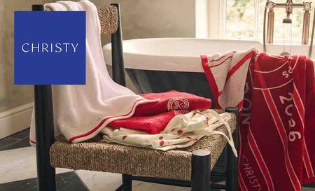 christy logo top left with red towels in a bathroom