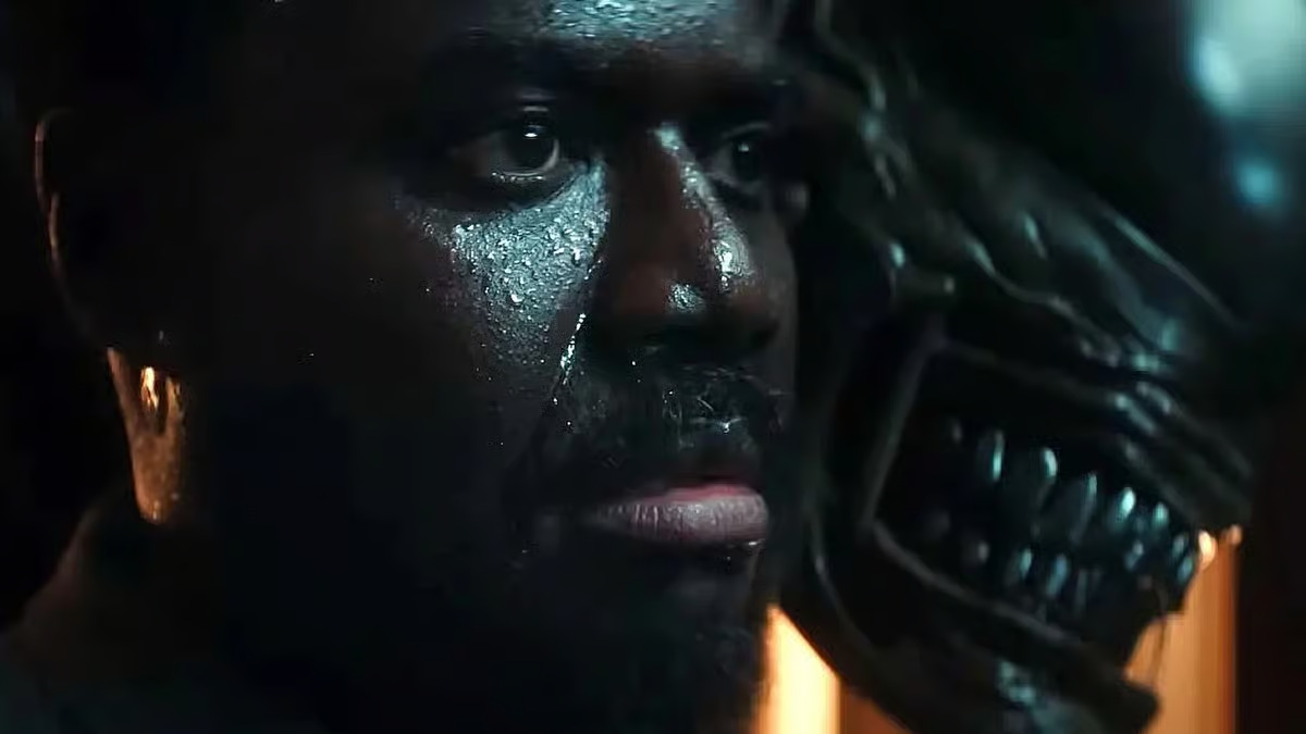 A close up of a sweating Morror as a Xenomorph sneers behind him in Alien: Earth