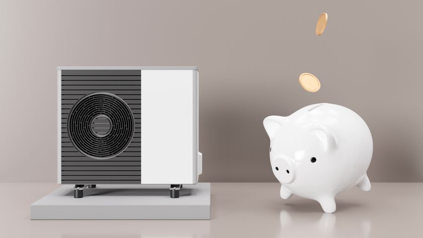 model of heat pump with white piggy bank next to it and coins falling in