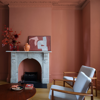 a red living room with marble fireplace and two armchairs by a coffee table