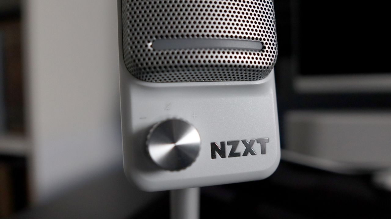 An NZXT Capsule Elite microphone set up on a desk with lighting enabled.