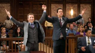 Breckin Meyer and Mark-Paul Gosselaar hold hands in the air in a courtroom in Franklin and Bash
