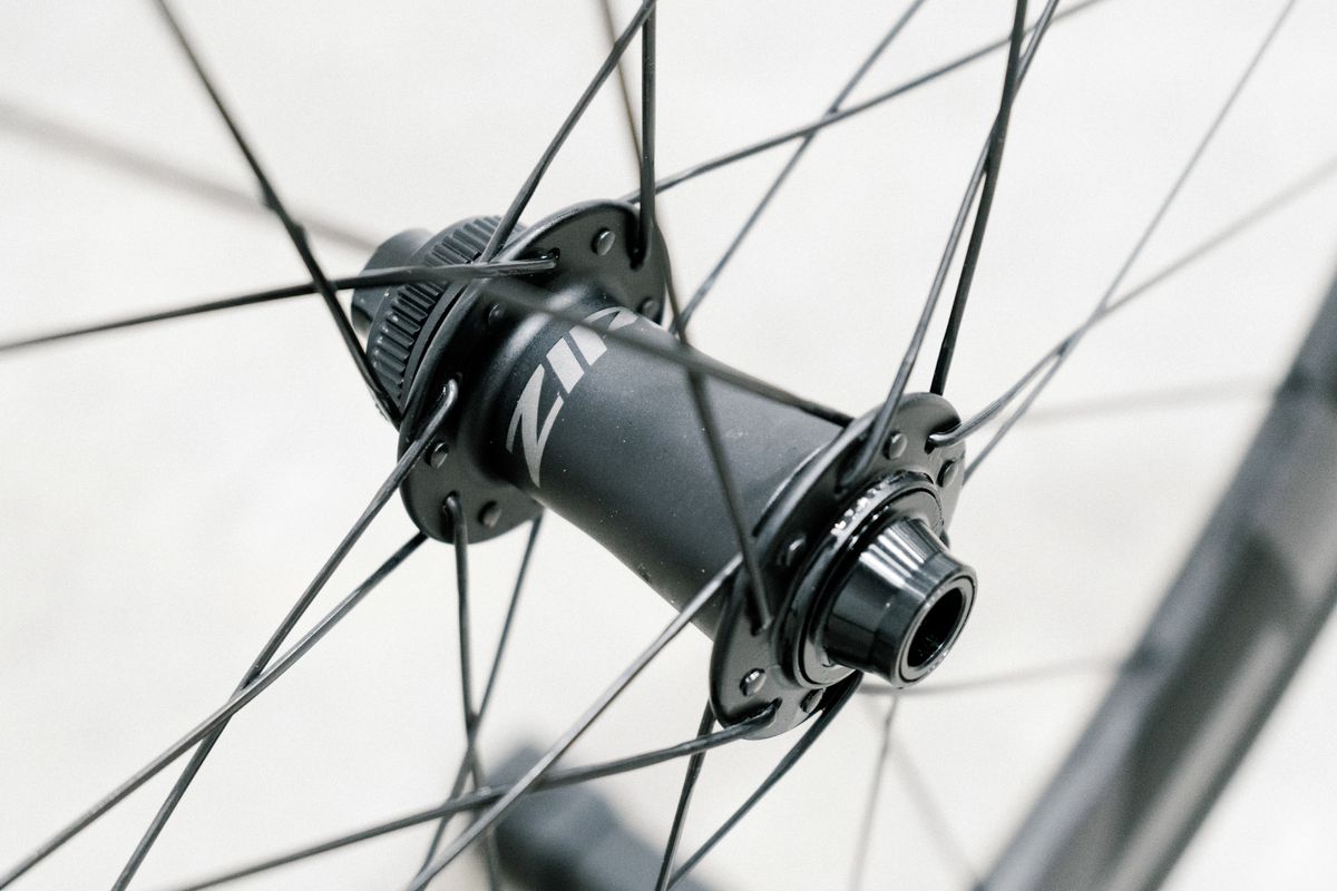An aero road wheel stands against a white wall